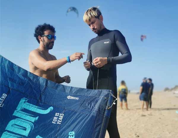 Instructeur expliquant à son élève comment attacher les lignes à son aile de kite.